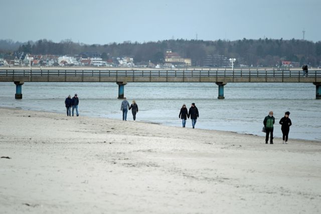People walk at the beach by the Baltic Sea amid COVID-19 pandemic in Scharbeutz