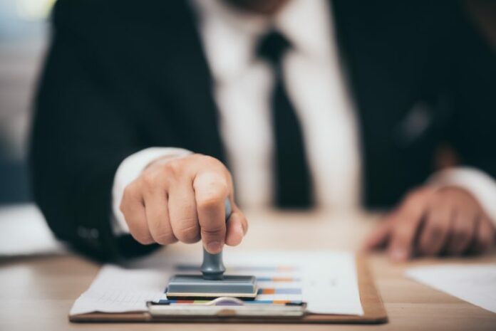 young-business-man-appoval-stamper-stamp-on-paper-LANPYKU-1-768x513